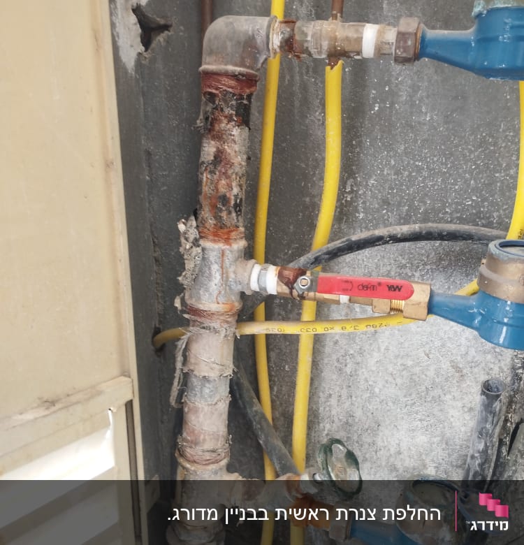 צינורות מים עם חלודה ושסתומים כחולים